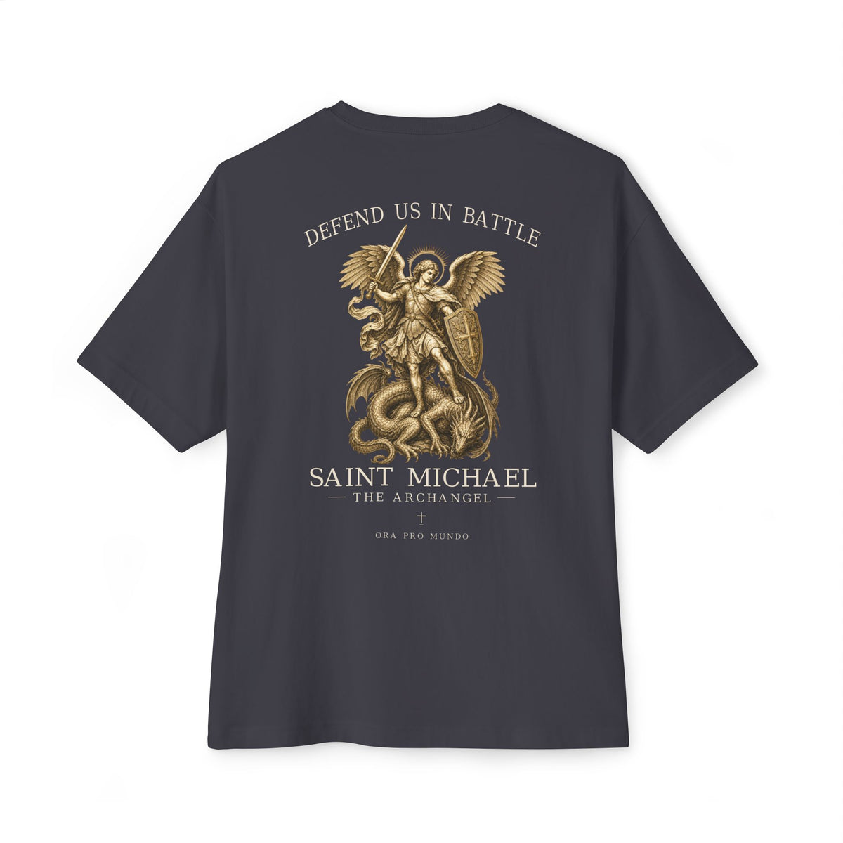 A dark charcoal gray t-shirt shown from the back, featuring a large gold graphic of Saint Michael the Archangel defeating a serpent. The text 'DEFEND US IN BATTLE' is printed above the graphic, and 'SAINT MICHAEL THE ARCHANGEL' is printed below.
